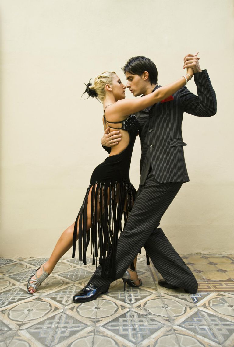 a man and woman wearing black and dancing