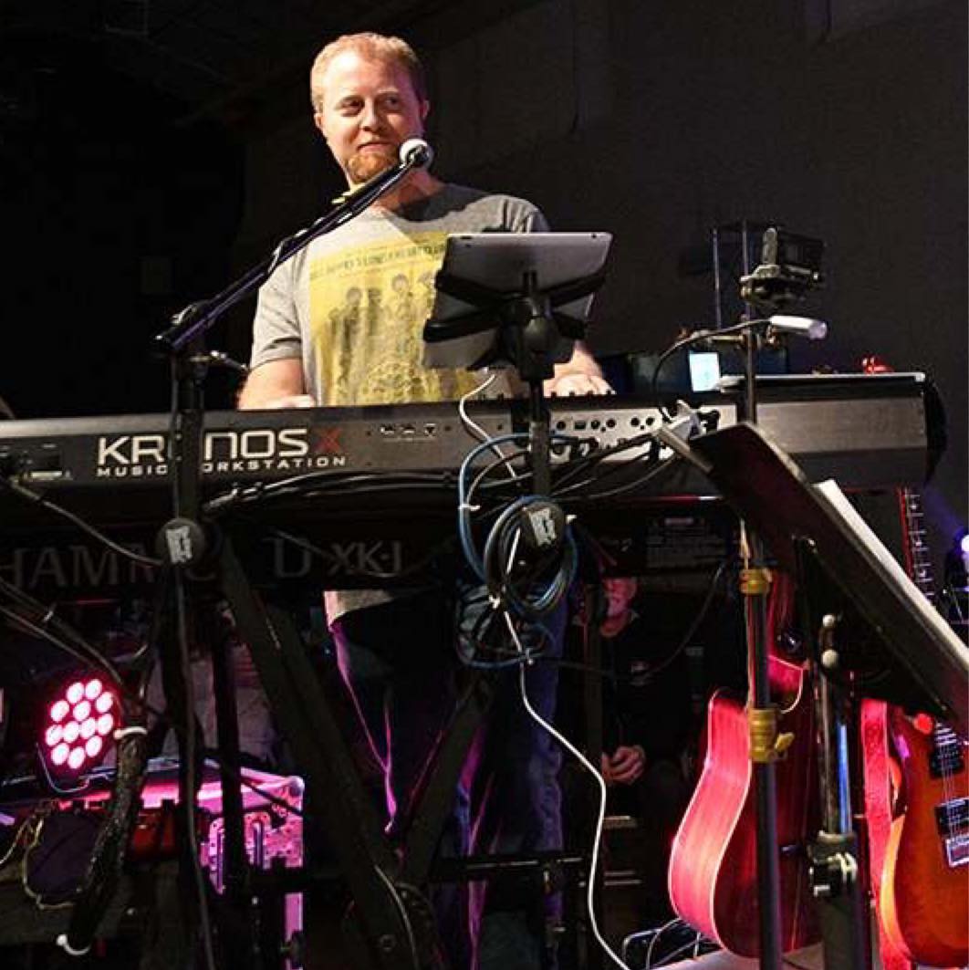 man playing a keyboard in front of a microphone