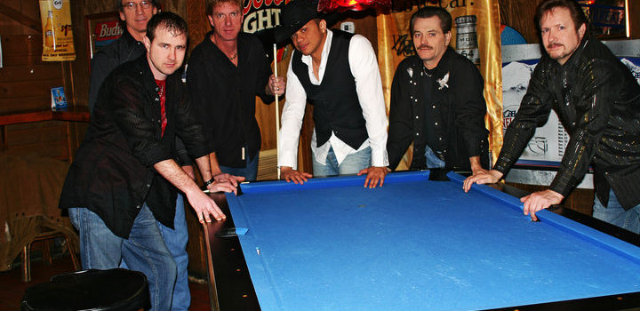 6 men standing around blue pool table