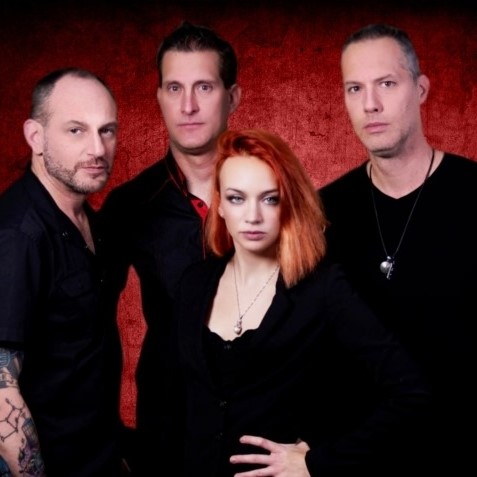 red haired woman standing with 3 men wearing black shirts