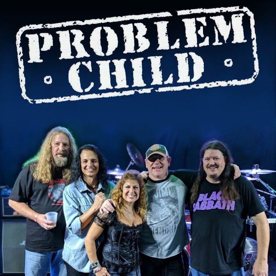 5 people posing under problem child in white distressed lettering